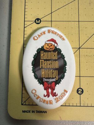 Disneyland button features "Haunted Mansion Holiday" with a pumpkin wearing a Santa hat cast preview from October 2001