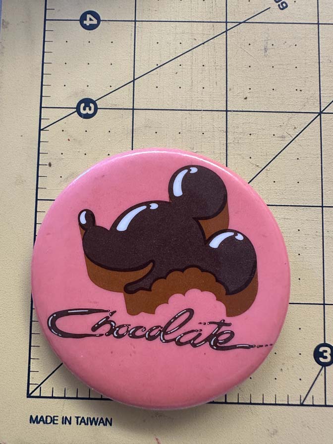 Chocolate Mickey Mouse with a bite out of him button
