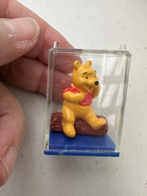 Winnie the Pooh collectible figure is encased in a clear plastic display box with a blue base