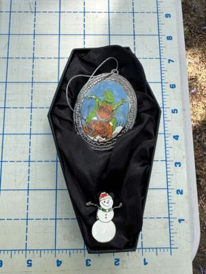 Nightmare Before Christmas themed gift set features items tucked into a black, coffin-shaped display box Oogie with Snowman Pin