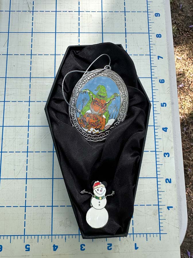Nightmare Before Christmas themed gift set features items tucked into a black, coffin-shaped display box Oogie with Snowman Pin