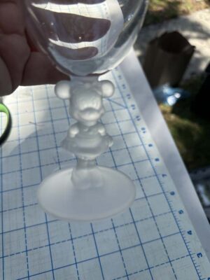 Disney collectible wine glass, specifically featuring a frosted glass stem sculpted in the likeness of Minnie Mouse
