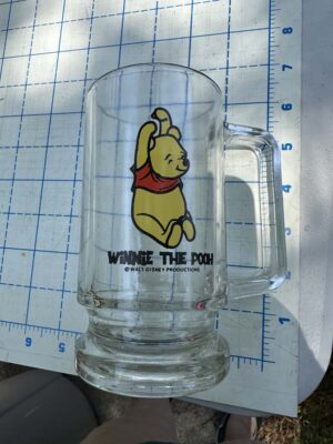 Walt Disney Productions Winnie the Pooh clear glass footed mug featuring the character sitting with his arms raised
