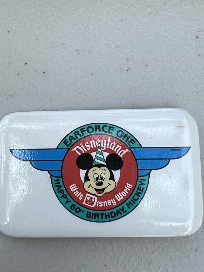 1988 features the "Earforce One" logo celebrating Mickey Mouse's 60th birthday button